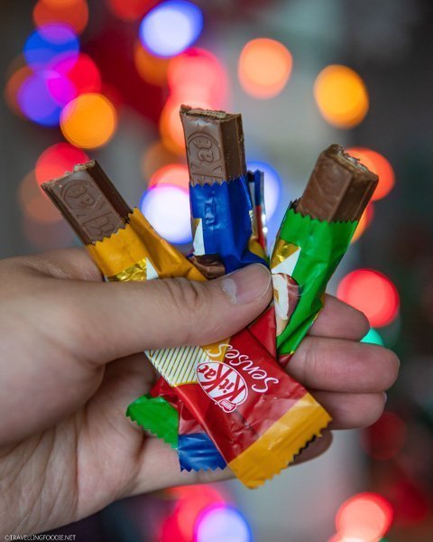 Holding all 3 new flavours of KITKAT Senses with bokeh lights