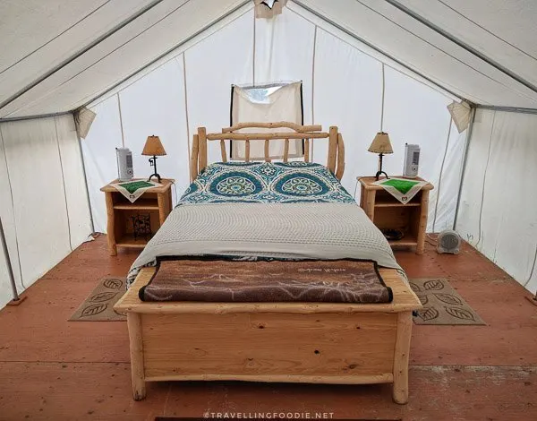 Queen bed inside glamping tent at WildExodus in Timmins, Ontario