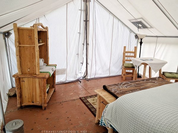 Log furniture inside glamping tent at WildExodus in Timmins, Ontario