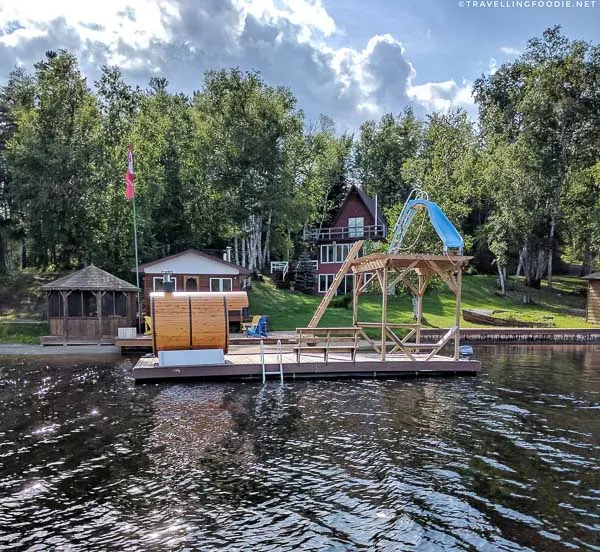 Cottage dock with sauna and slide during pontoon boat cruise