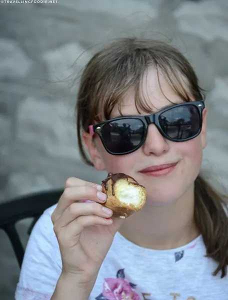 Girl holding cream puff at Urban Patisserie in Port Dover, Norfolk County, Ontario