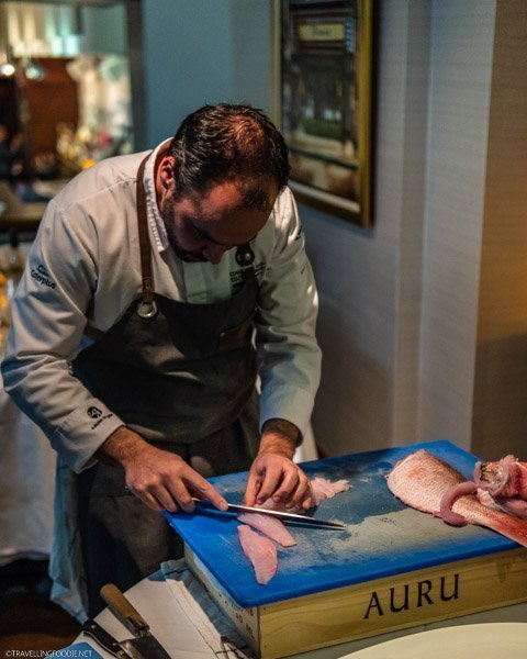 Chef Joao Dias slicing fish for Air Canada Vacations event at Ferreira Cafe in Montreal, Quebec