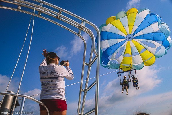 Lady waving Father and Son parasailng in Daytona Beach, Florida