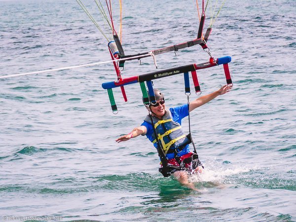 Travelling Foodie Raymond Cua knee deep in water at Daytona Beach Parasailing