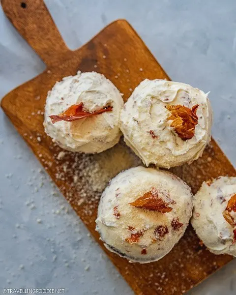 Top-down of three Prosciutto and Cheese Cupcakes sprinkled with cheese on tray