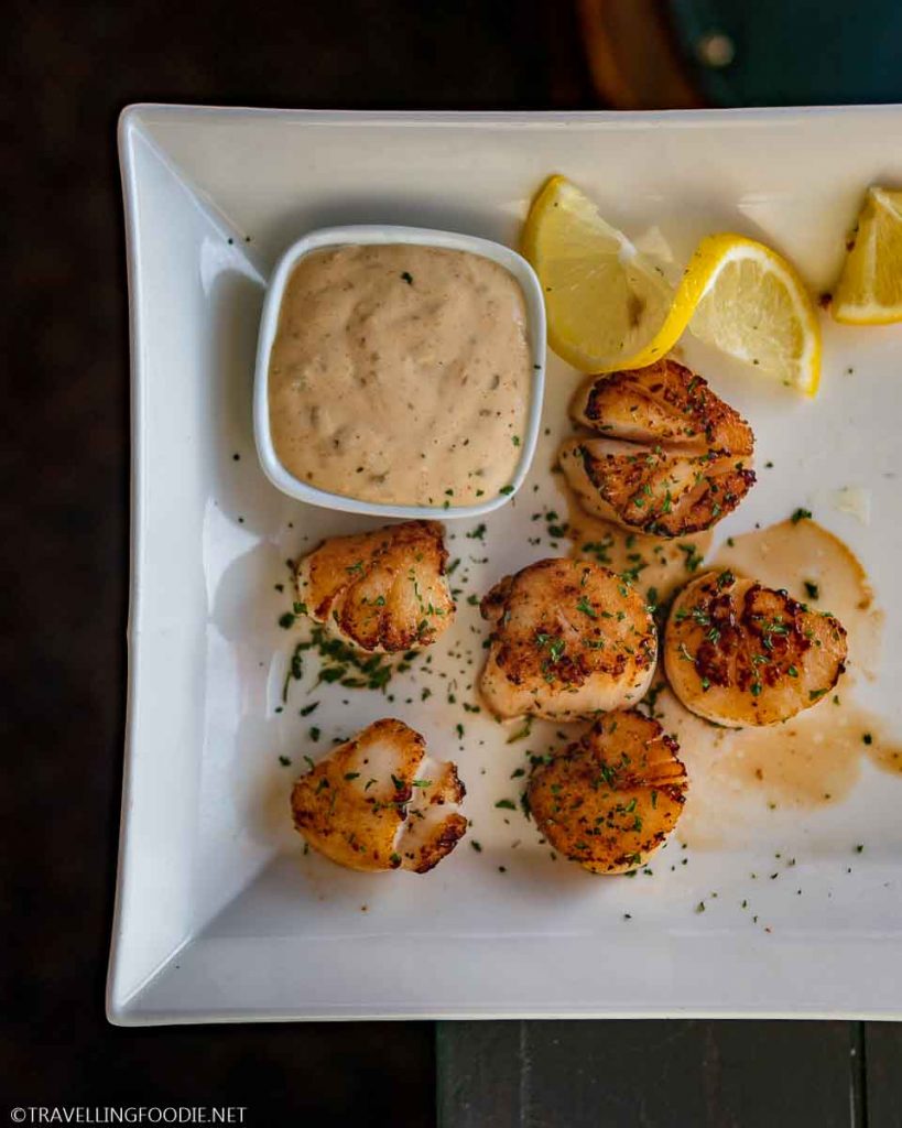 Six Digby Scallops with sliced lemon and remoulade at Argyler Lodge in Argyle, Nova Scotia