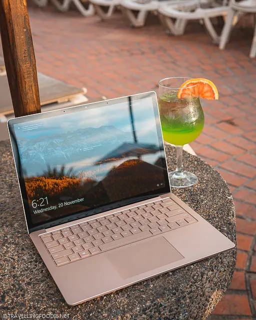 Microsoft Surface Laptop 3 with a cocktail on pool table