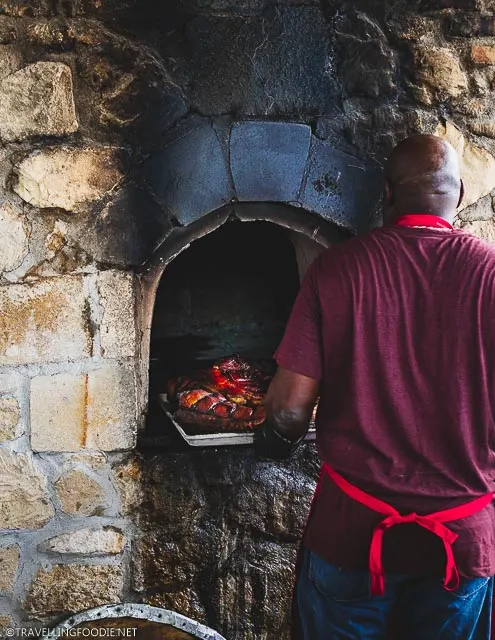 Chef taking out roast pork from Dutch oven at USVI Agrifest in St. Croix