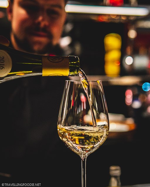 Pouring Puligny Montrachet Wine on Wine Glass at L'Atelier de Joel Robuchon for Montreal en Lumiere 2020 Tasting Menu