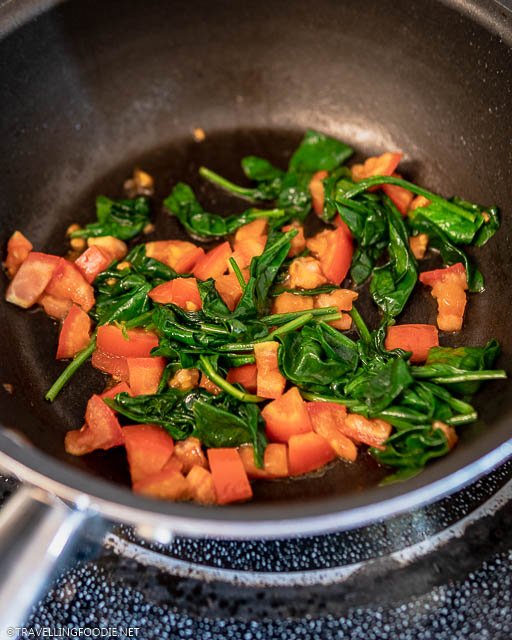 Saute tomatoes and spinach on pan