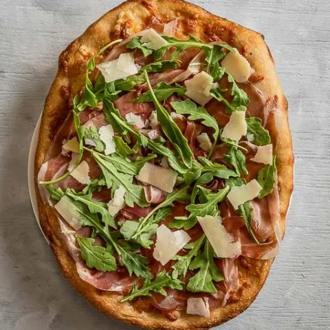 Whole Prosciutto and Arugula Cheese Italian Pizza on a Plate