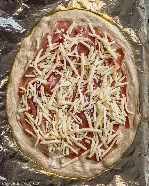 Parma Ham and Mozzarella Cheese on top of raw Pizza Dough
