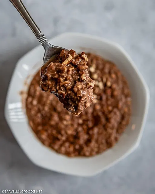 Cacao oatmeal with crushed almonds in a spoon