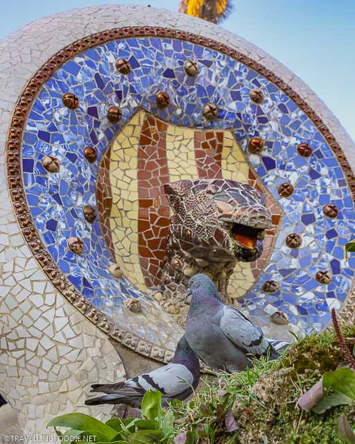 Mosaic Serpent Head Fountain at Park Guell with pigeons
