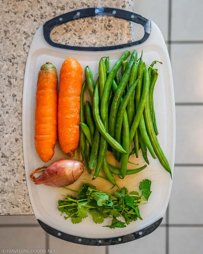 Onion, Cilantro, Green Beans and Carrots on chopping board