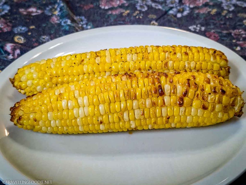 Steam and air fried corn on the cob on plate
