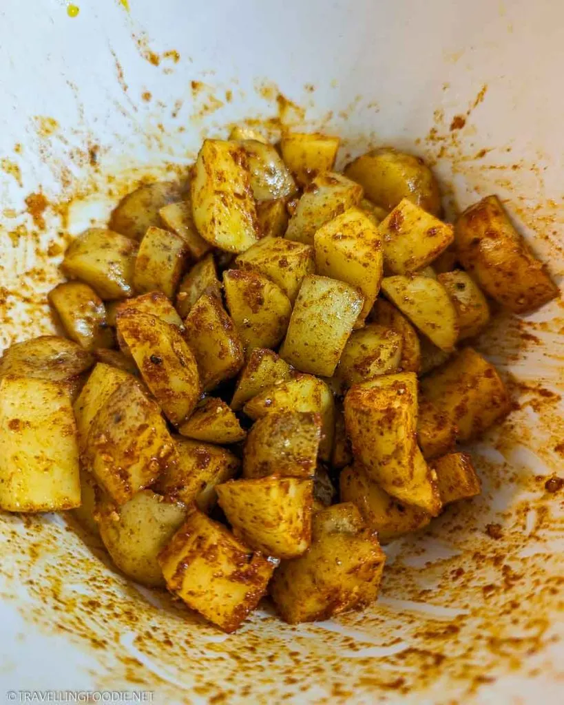 Seasoned and cut potatoes in bowl