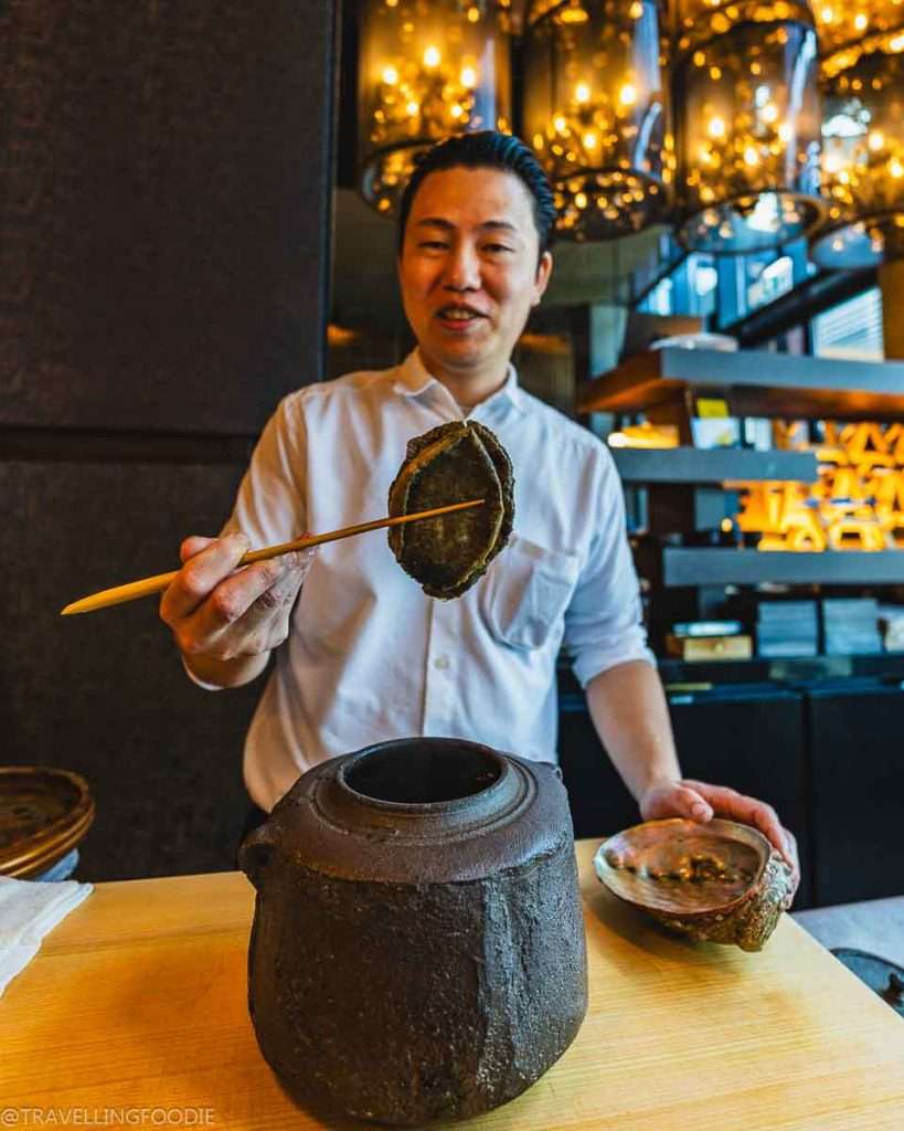 Chef Takashi Namekata holding Japanese black abalone at TakaHisa Japanese Restaurant at Banyan Tree Dubai Hotel