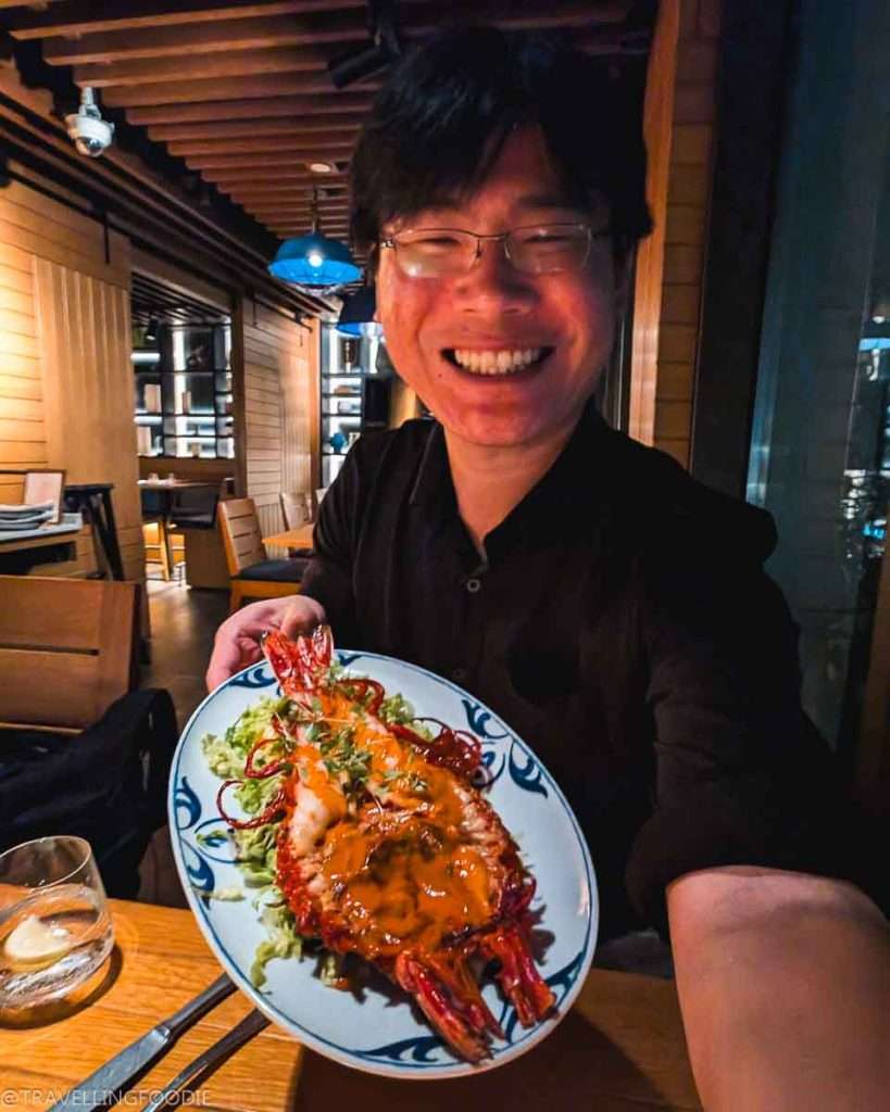 Travelling Foodie Raymond Cua holding Scarlet Shrimp at Tasca, One Michelin Star Portuguese Dubai Restaurant