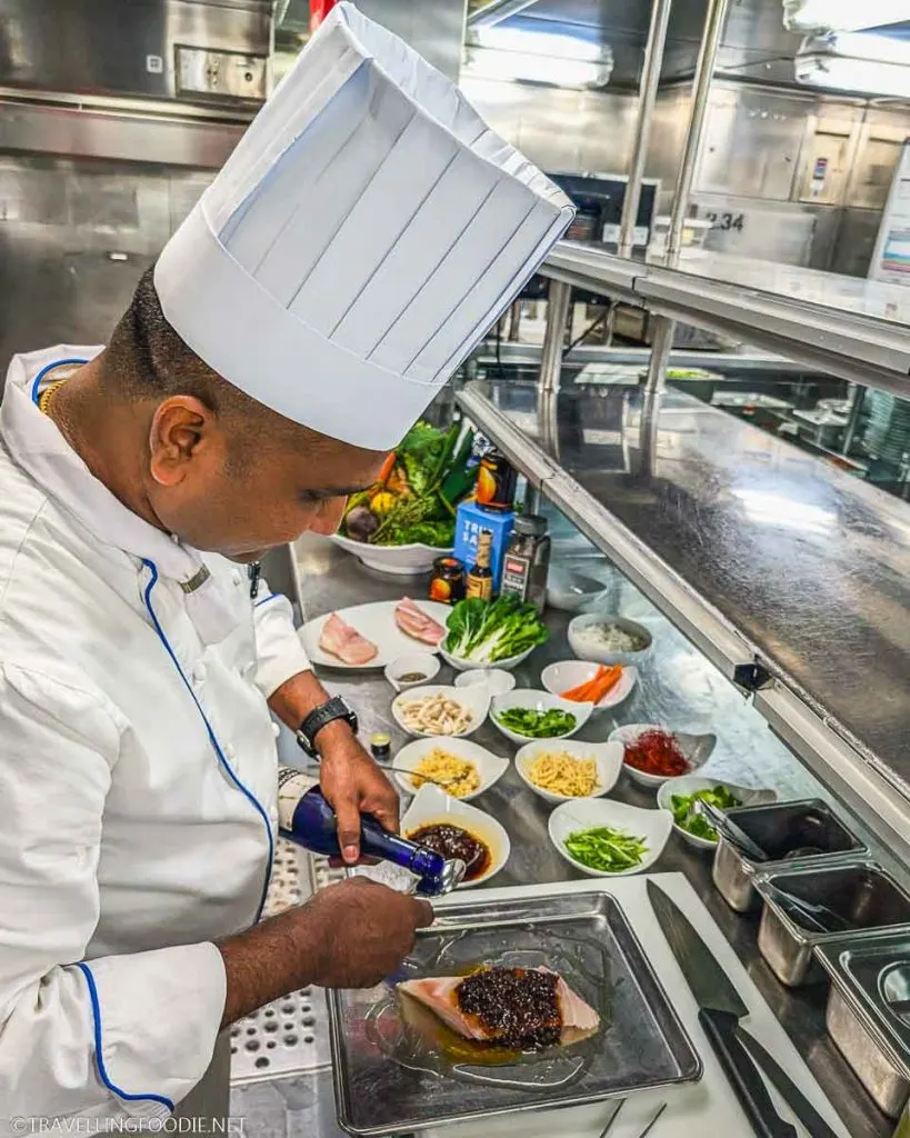 Sous Chef Jacob Jeejo preparing Fish in XO sauce at Holland America Nieuw Amsterdam