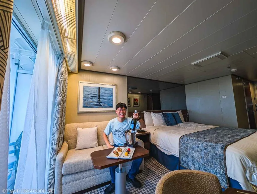 Travelling Foodie Raymond Cua at Holland America Nieuw Amsterdam Verandah Spa Stateroom holding La Marca Prosecco DOC