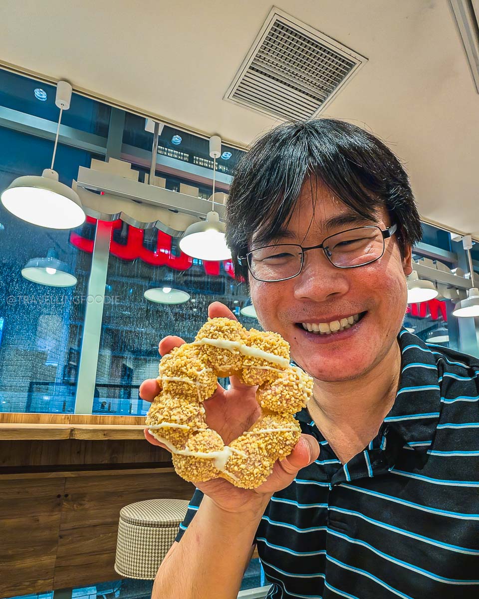 Travelling Foodie Raymond Cua holding Mochi Doughnut at Mister Donut Ikebukuro