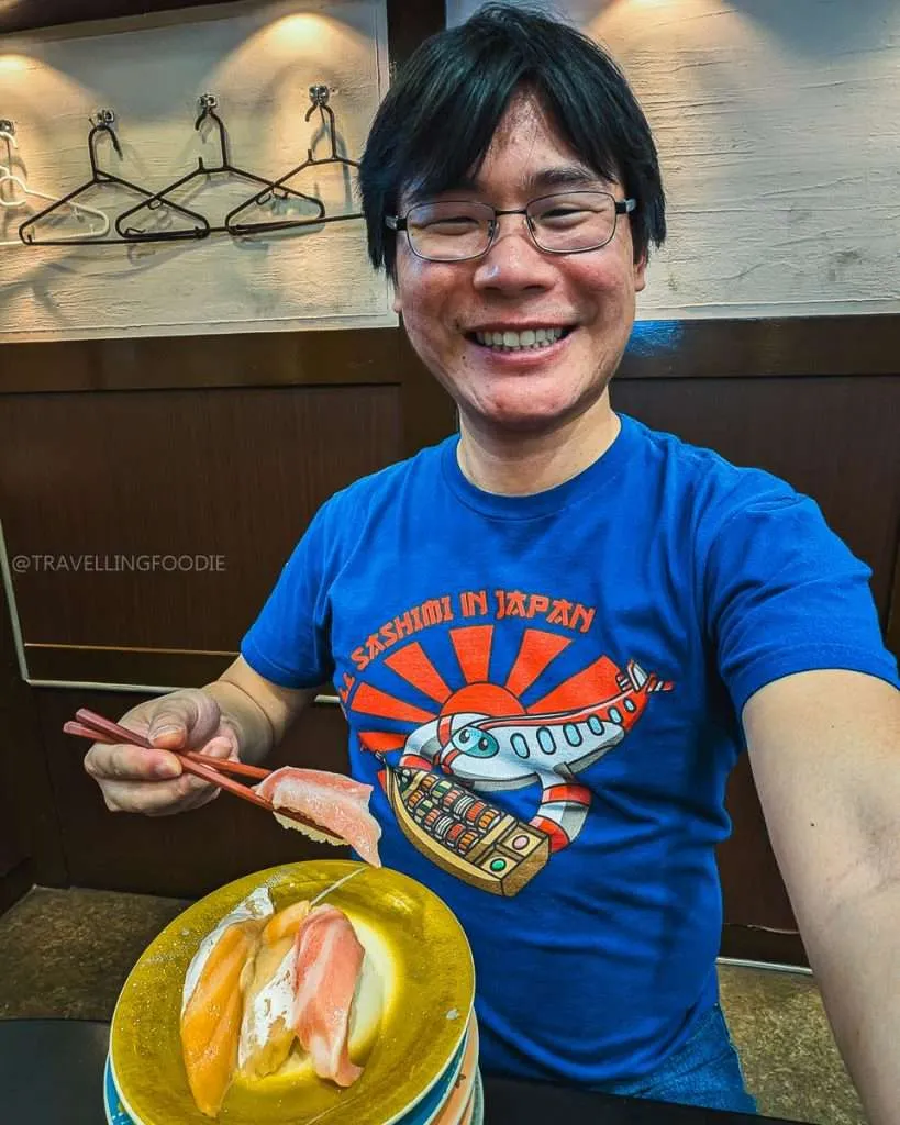 Travelling Foodie Raymond Cua enjoying nigiri at conveyer belt sushi restaurant in Shinjuku Tokyo