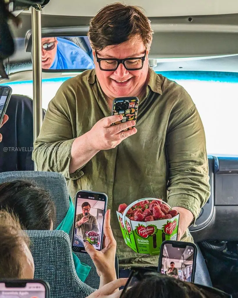 Allison Van Rassel taking pictures of OhBio strawberries during Île d’Orléans Food Tour