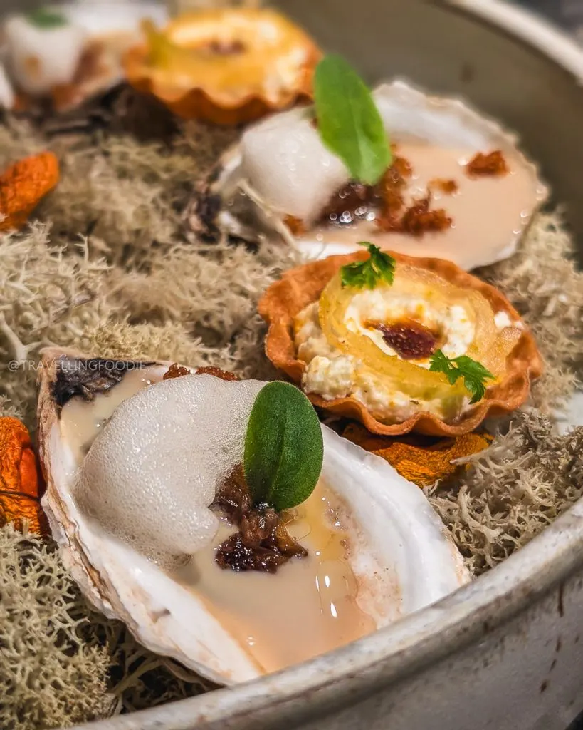 Oysters with foam and savory tarts on moss at Taniere3, a North America's 50 Best restaurant in Quebec City.
