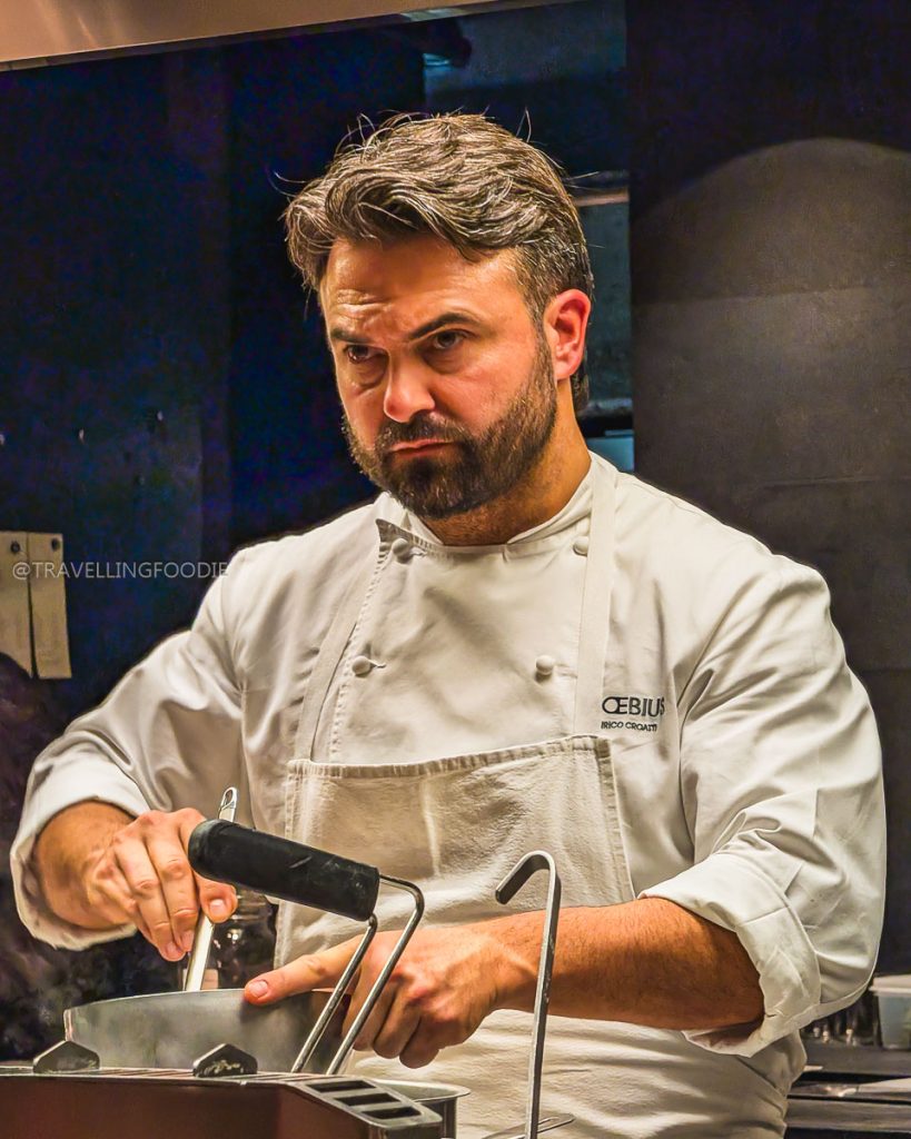 Close-up of Executive Chef Enrico Croatti focused on cooking in the open kitchen of Moebius Sperimentale in Milan