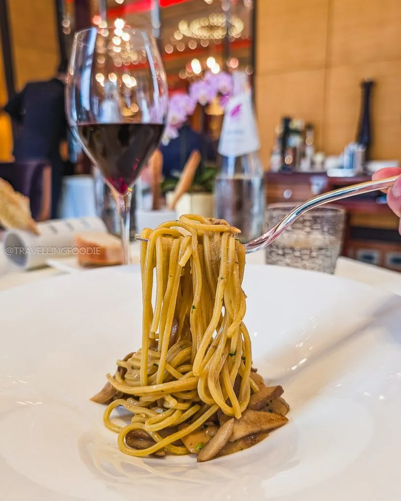 Fork lifting homemade Tagliolini pasta with Porcini mushrooms at Ristorante Acanto Milan.