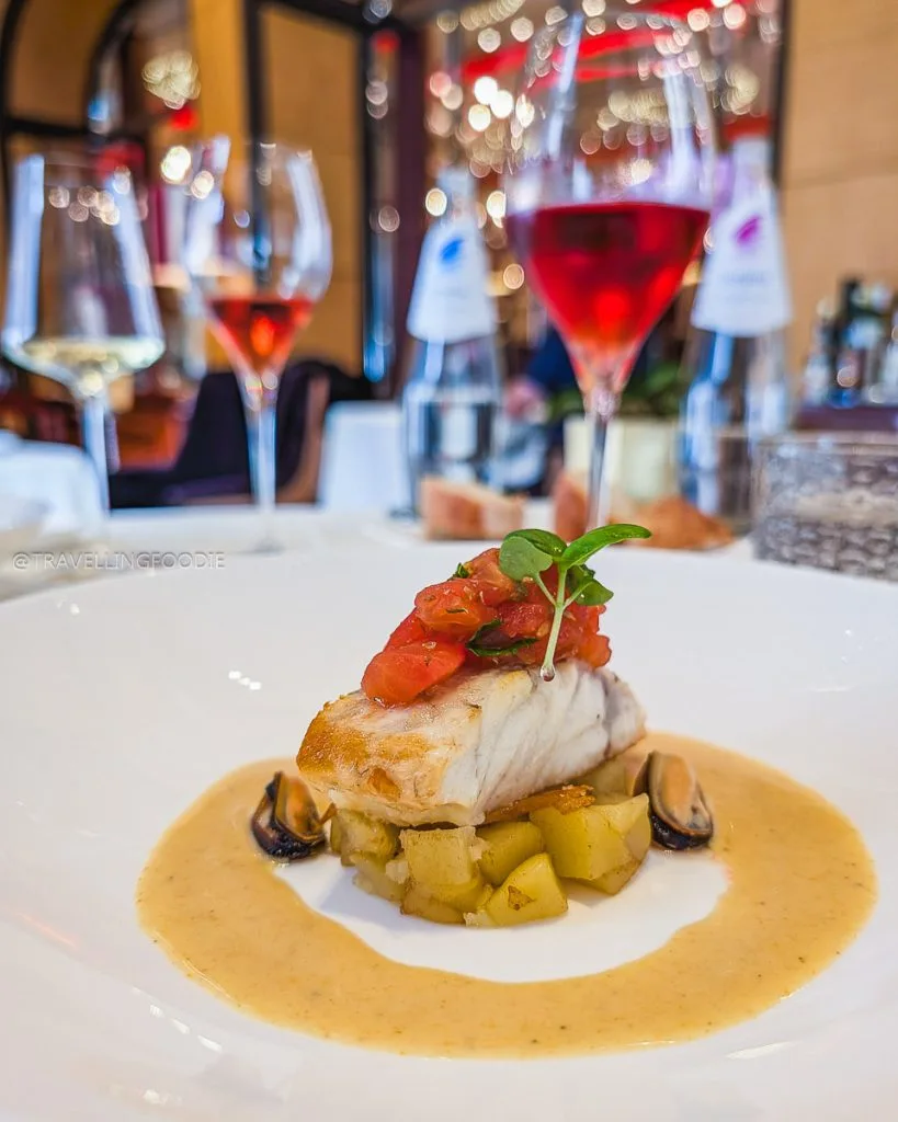 Sea bass fillet with roasted tomato pesto and mussel cream sauce at Acanto Restaurant Milan.