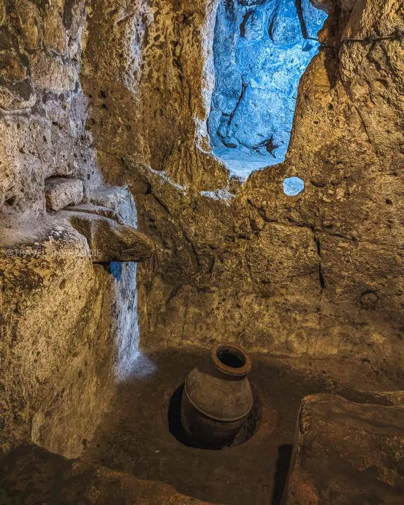 Deep ventilation shaft and ancient clay wine storage area inside the Derinkuyu Underground City in Cappadocia
