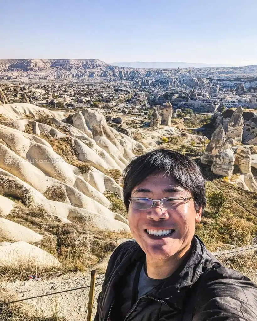 Raymond Cua taking a selfie at Goreme Panorama with the sprawling Cappadocian landscape and fairy chimneys behind