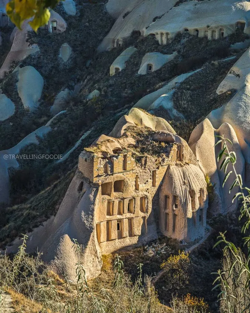 Close-up of a rock structure filled with carved windows and pigeon nests in Pigeon Valley