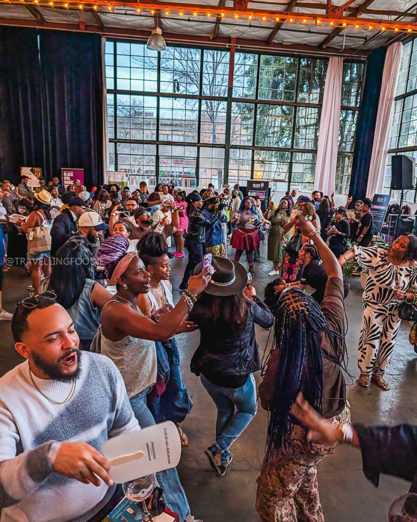 Guests dancing and enjoying live music at the Black Vines wine festival, highlighting Berkeley's diverse culture.