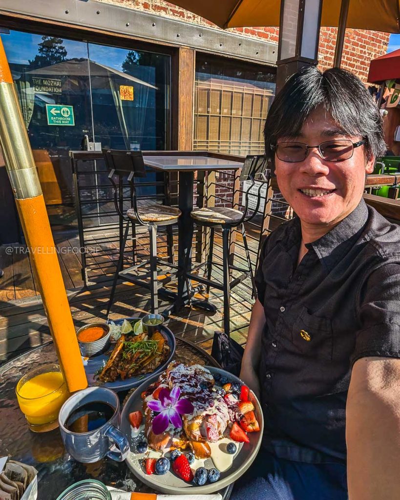 Travelling Foodie Raymond Cua enjoying a hearty brunch at Eggy's Neighborhood Kitchen, exploring the top places to eat in Berkeley.