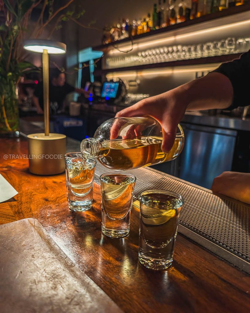 A bartender pouring strong house-aged Chinese Baijiu at Great China, a thrilling Berkeley drink experience.