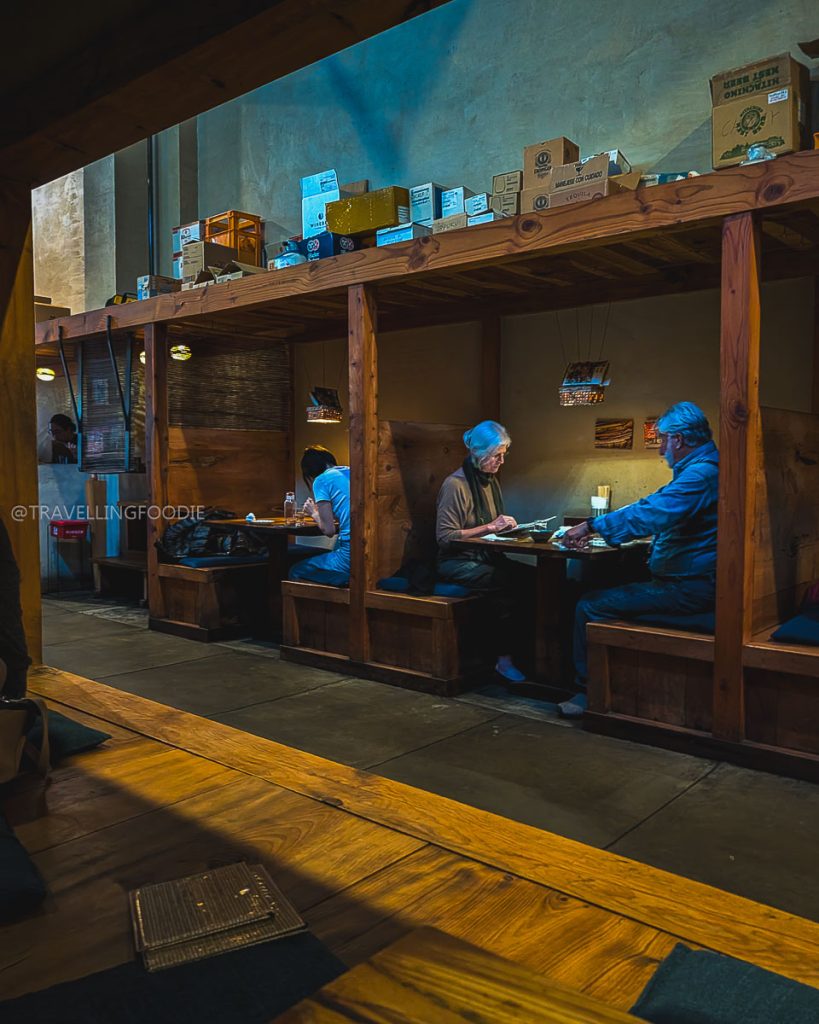 Atmospheric wooden dining booths inside Ippuku, a Michelin-recognized destination for the best restaurants in Berkeley.