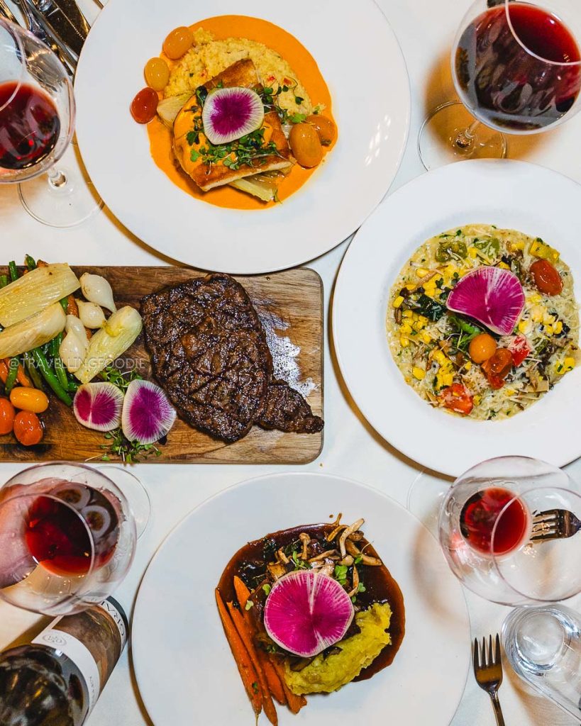 Top-down view of steak, halibut, and fine dining dishes at Julia's Restaurant, a top Berkeley restaurant in the City Club.