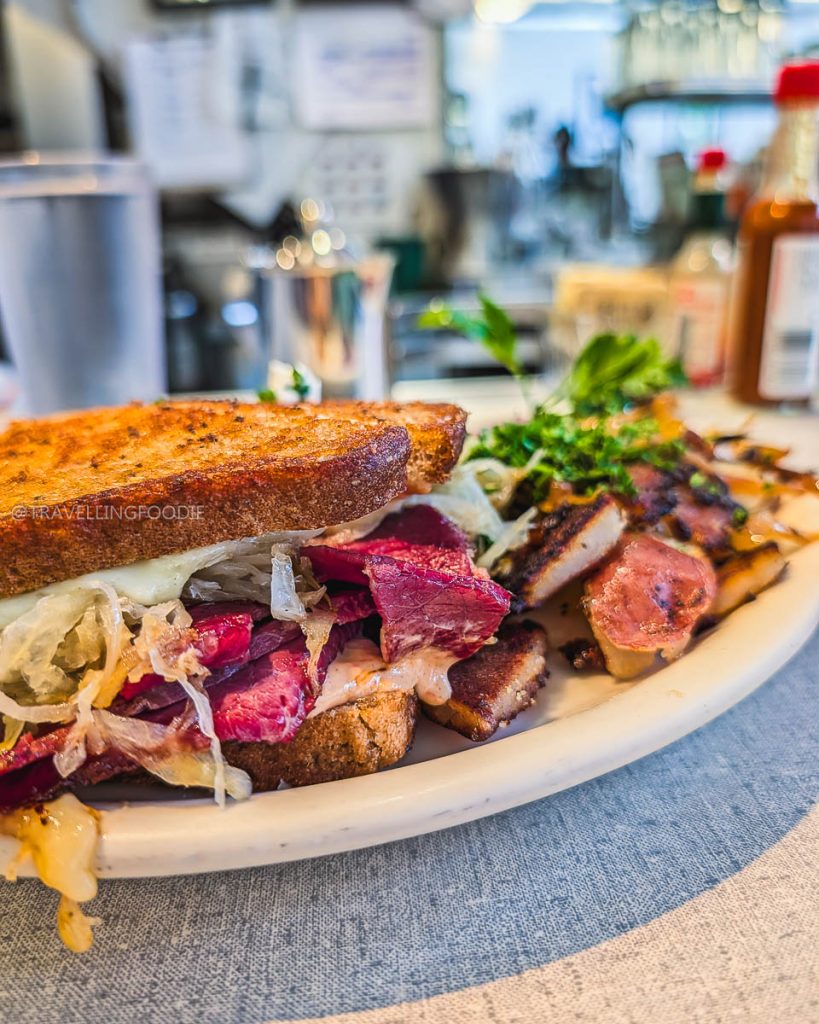 Close up of a classic Grilled Reuben sandwich and home fries at Oceanview Diner, a must-visit place to eat in Berkeley.