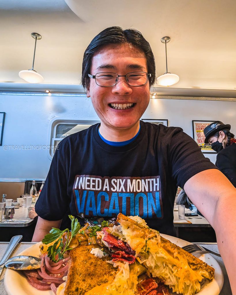 Travelling Foodie Raymond Cua with a massive classic grilled Reuben sandwich at Oceanview Diner, one of the best breakfast restaurants in Berkeley.
