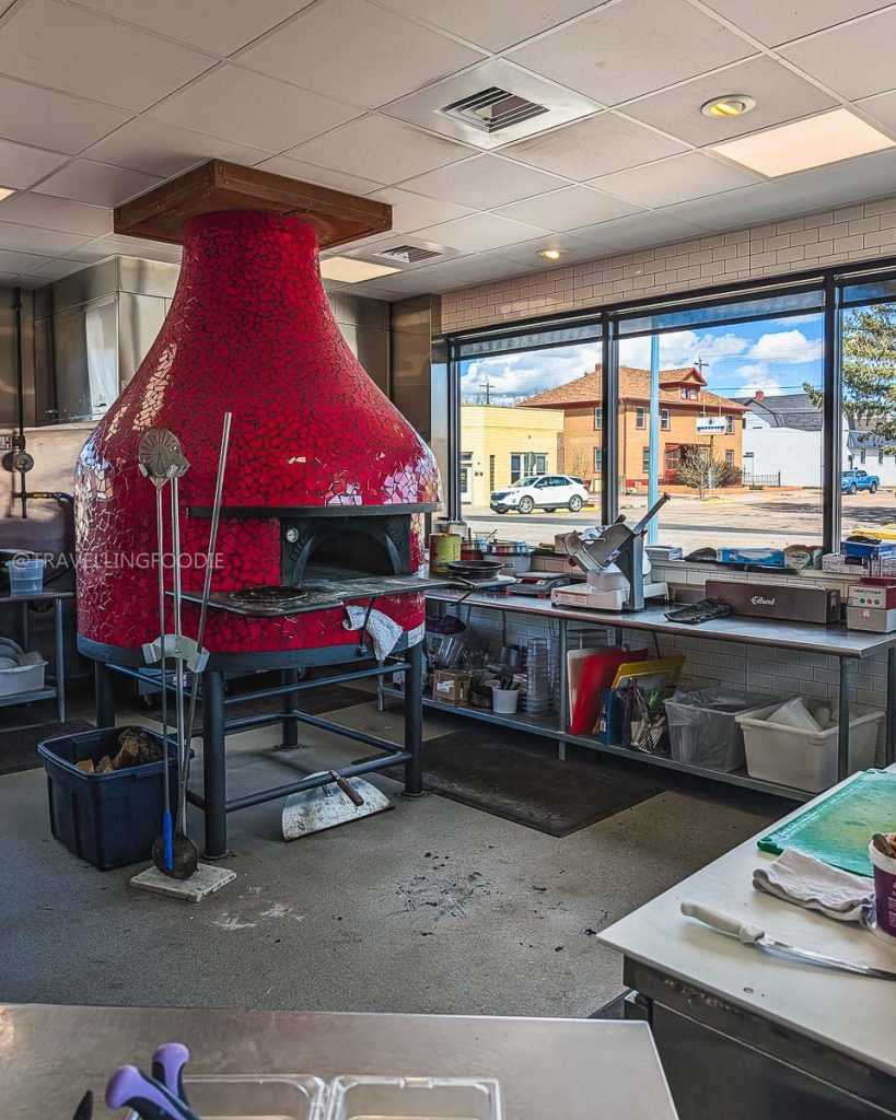 Bright red Stefano Ferrara wood-fired pizza oven inside Alibi, one of the best restaurants in Laramie Wyoming.