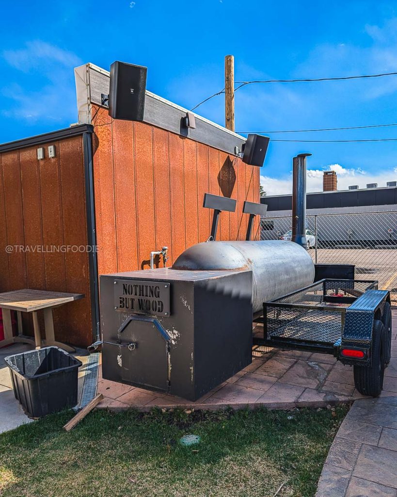 Large custom outdoor wood smoker for smoking briskets at Alibi, a must-visit spot for delicious Laramie food.