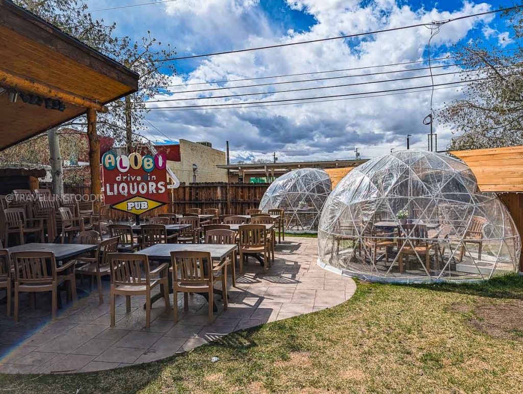 Alibi Pub outdoor patio featuring dining igloos and seating, highlighting fun things to do in Laramie's food scene.