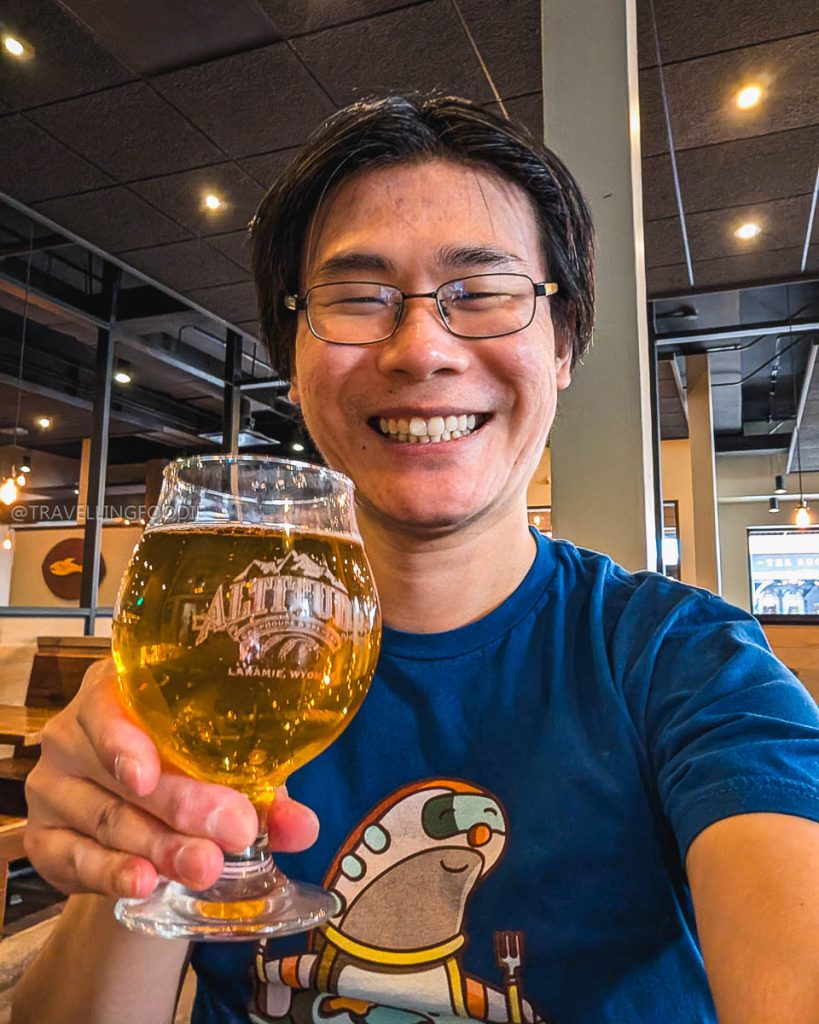 Travelling Foodie holding a Chili Ale craft beer at Altitude Chophouse and Brewery, one of the best bars in Laramie.