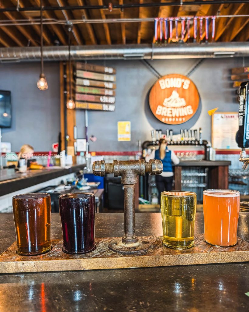 A colorful craft beer flight on the bar counter at Bond's Brewing Company, one of the best bars in Laramie.