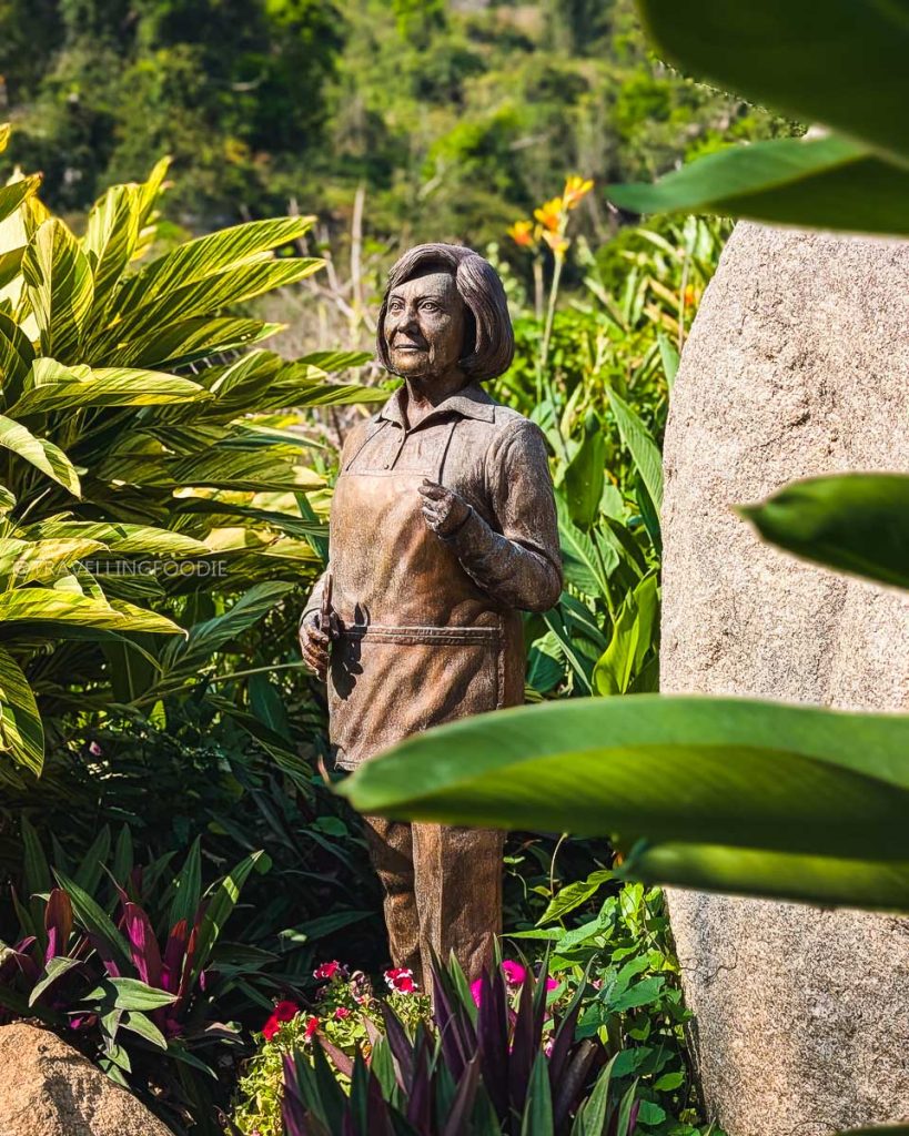 Bronze statue of a woman surrounded by lush tropical plants at the Acapulco Botanical Garden, a top Acapulco attraction.
