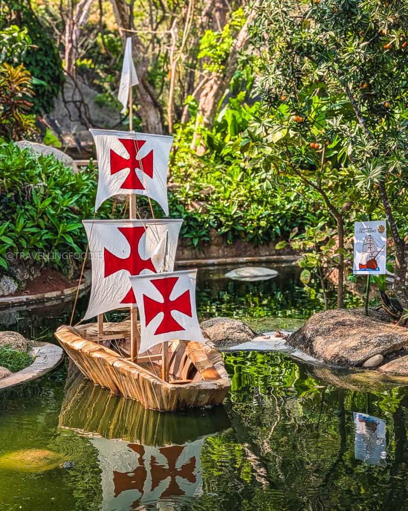 Small wooden Manila galleon ship floating in a garden pond, representing Acapulco's rich maritime trade history.