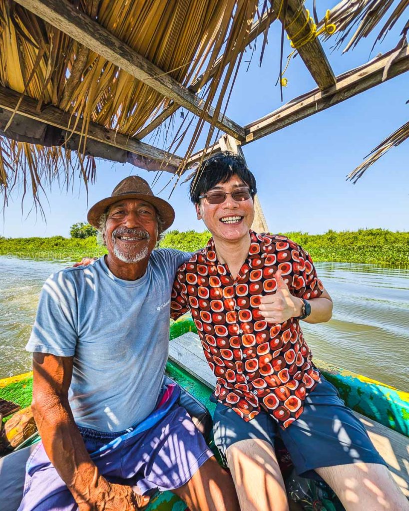 Raymond Cua smiling with a local boat captain during the scenic Coyuca Lagoon ecotour in Acapulco.